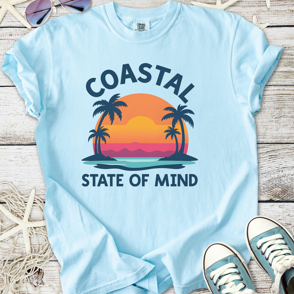 Light blue t-shirt with 'Coastal State of Mind' graphic and palm tree design, perfect for beach lovers.