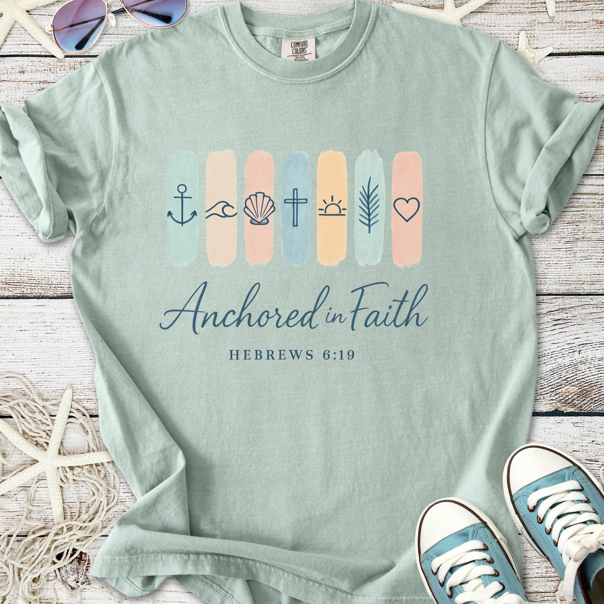 Mint green t-shirt with 'Anchored in Faith' graphic and nautical symbols, perfect for casual wear.
