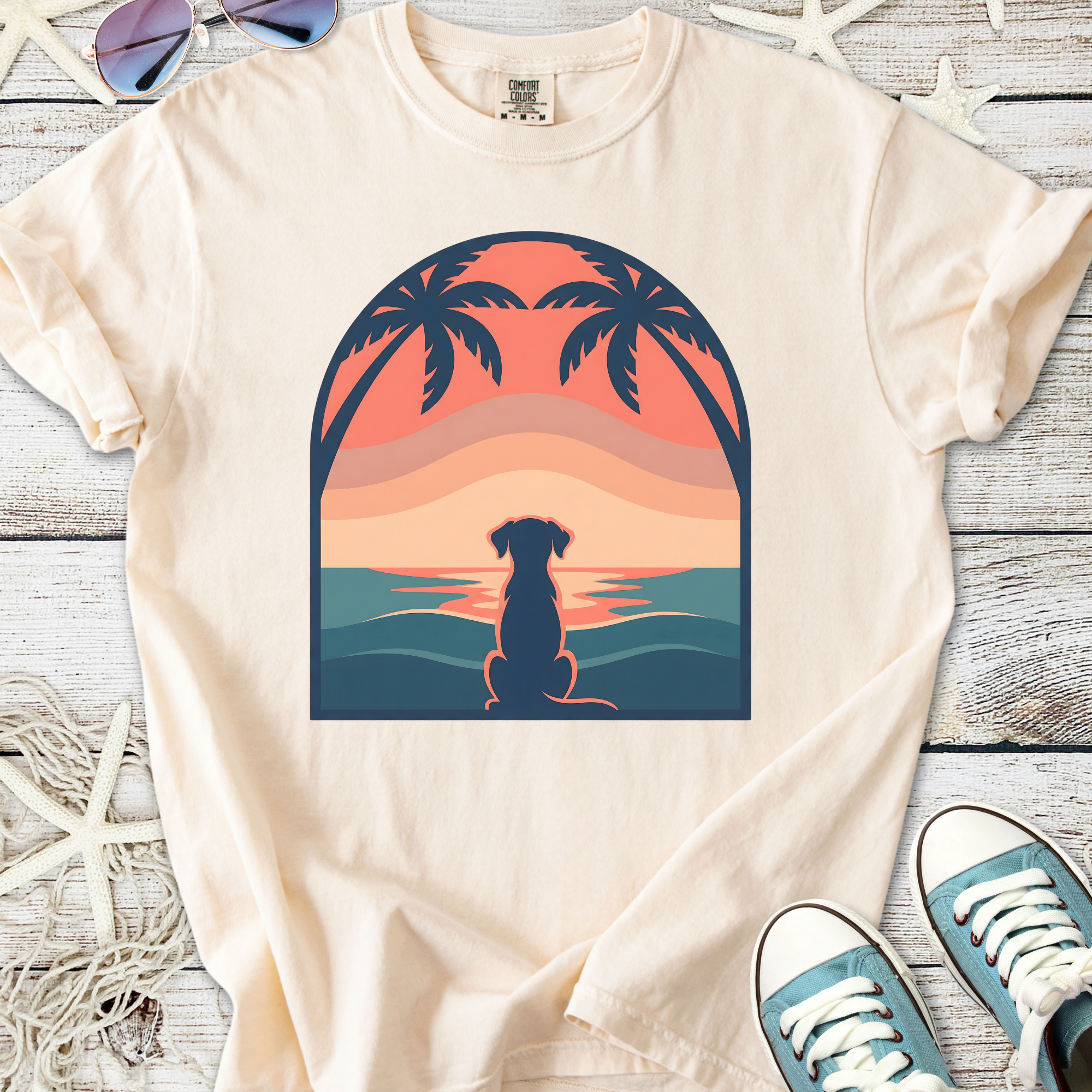 Cream t-shirt featuring a sunset dog silhouette design with palm trees, perfect for casual wear.