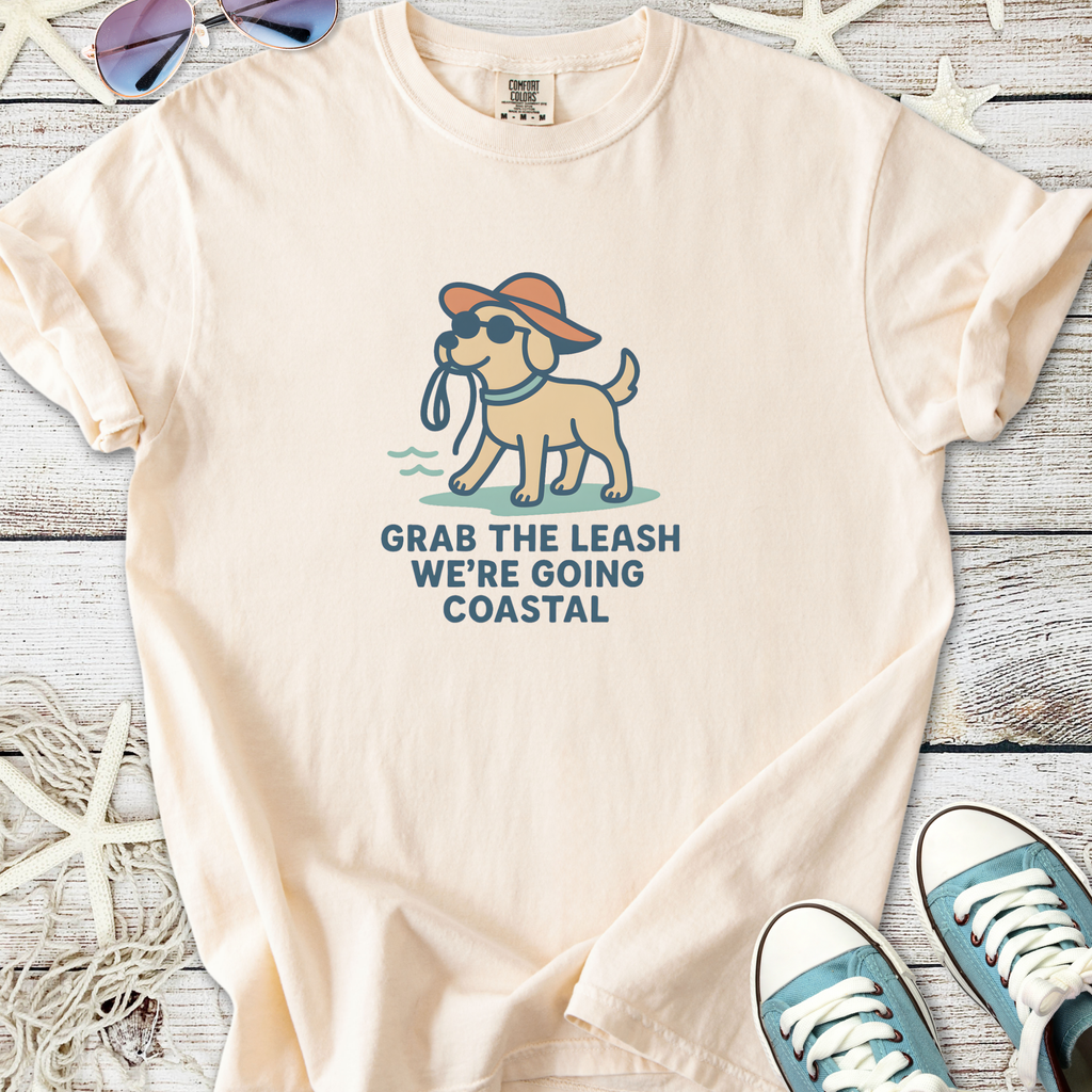 Light cream t-shirt with a playful dog graphic and 'Grab the leash, we’re going coastal' text.