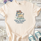 Light cream t-shirt with a playful dog graphic and 'Grab the leash, we’re going coastal' text.