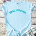 Light blue t-shirt featuring 'COASTAL STATE OF MIND' text, casual style, perfect for beach lovers.
