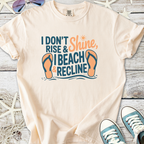 Cream t-shirt with beach-themed graphic: "I Don't Rise & Shine, I Beach & Recline" and flip-flops design.