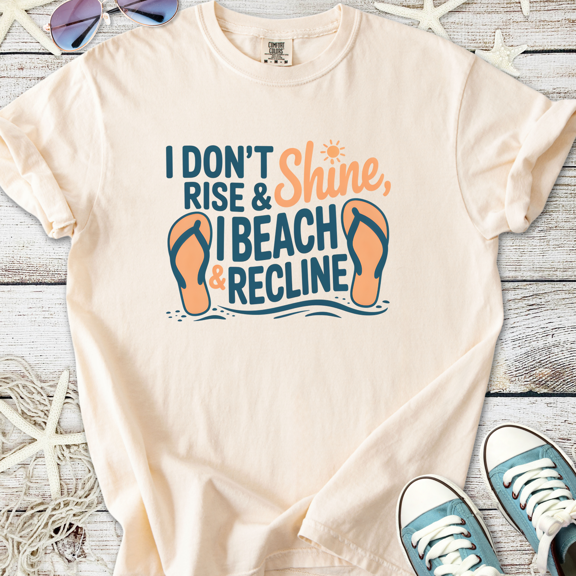 Cream t-shirt with beach-themed graphic: "I Don't Rise & Shine, I Beach & Recline" and flip-flops design.