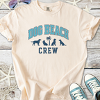 Beige cotton t-shirt featuring 'Dog Beach Crew' graphic and dog silhouettes, perfect for beach lovers.