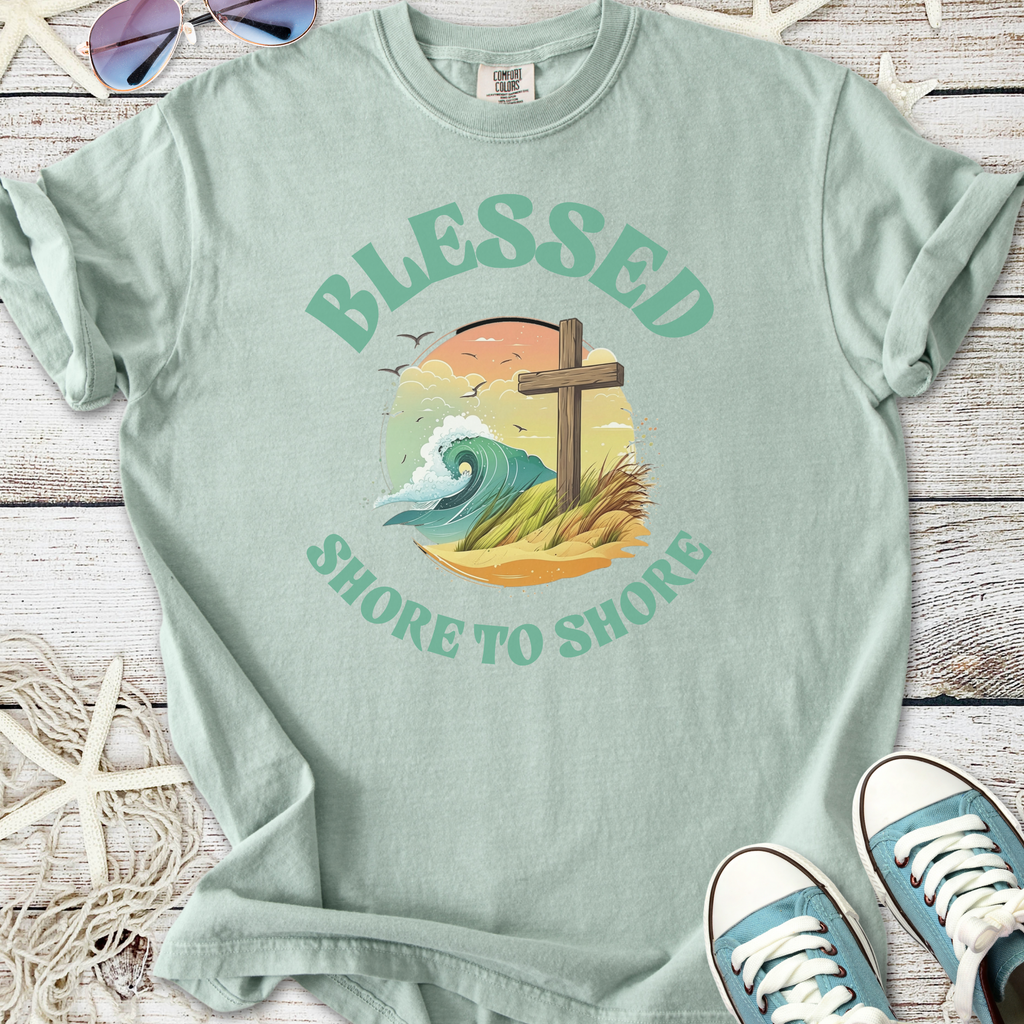 Mint green t-shirt featuring 'Blessed Shore to Shore' graphic with waves and a cross.