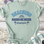 Mint green t-shirt with 'Beaching Makes Me Nicer' graphic print, ideal for summer style.