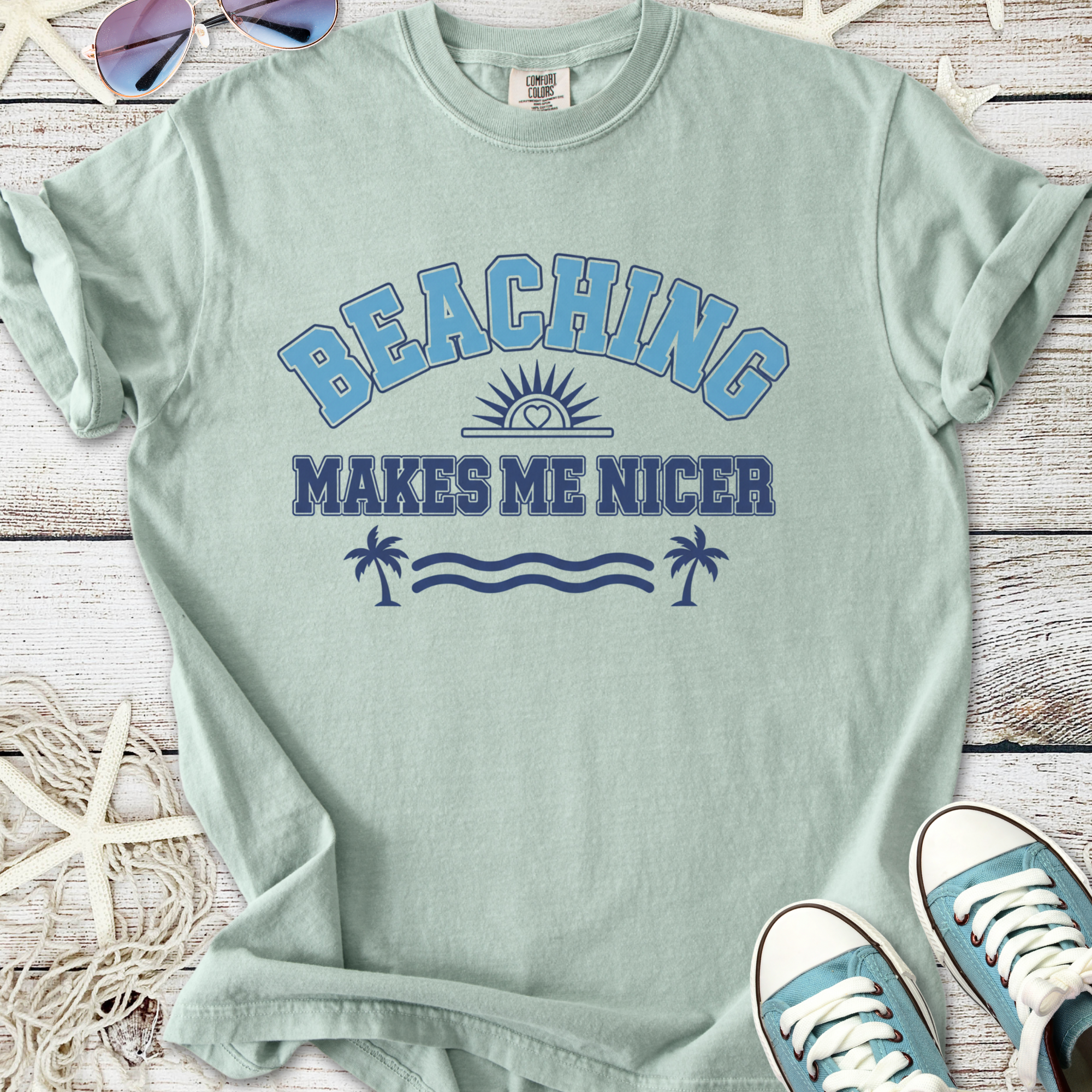 Mint green t-shirt with 'Beaching Makes Me Nicer' graphic print, ideal for summer style.