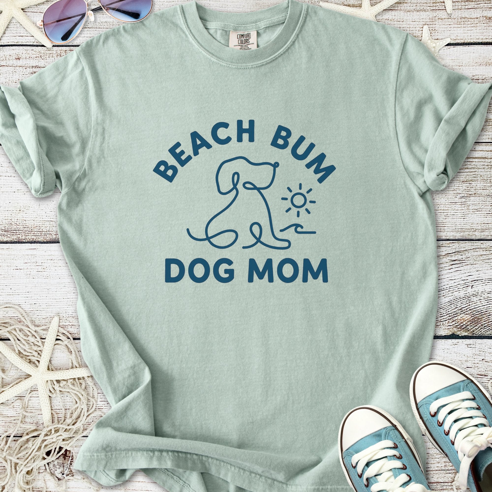 Light green t-shirt featuring 'Beach Bum Dog Mom' print, perfect for dog lovers and beach enthusiasts.