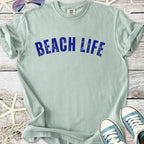 Light green t-shirt with 'BEACH LIFE' printed in bold blue, perfect for summer outfits.