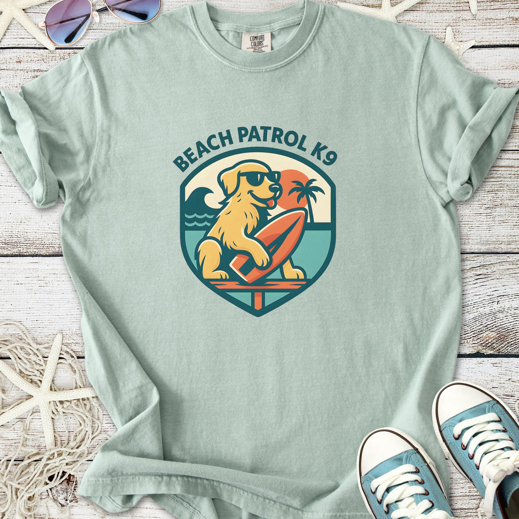 Light green Beach Patrol K9 t-shirt featuring a dog with sunglasses holding a surfboard, casual style.
