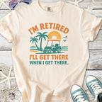 Cream retirement t-shirt featuring a golf cart, palm trees, and sunset graphic design.
