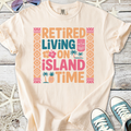 Cream t-shirt with colorful 'Retired Living on Island Time' graphic, perfect for beach lovers.