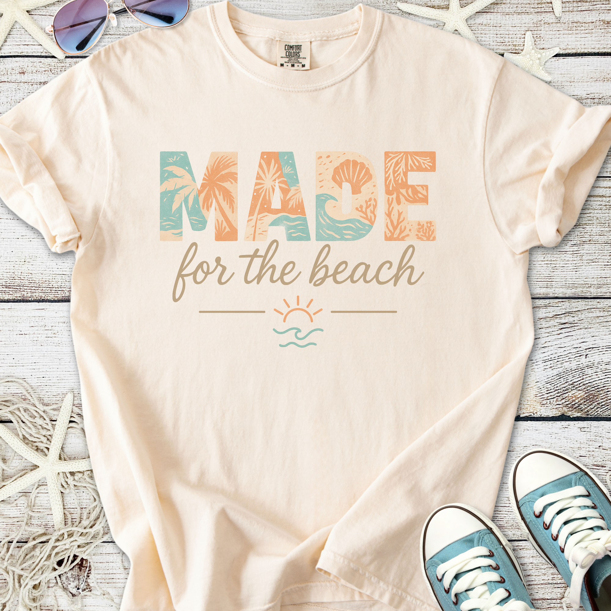 Light peach cotton t-shirt with 'MADE for the beach' graphic, perfect for casual beachwear.