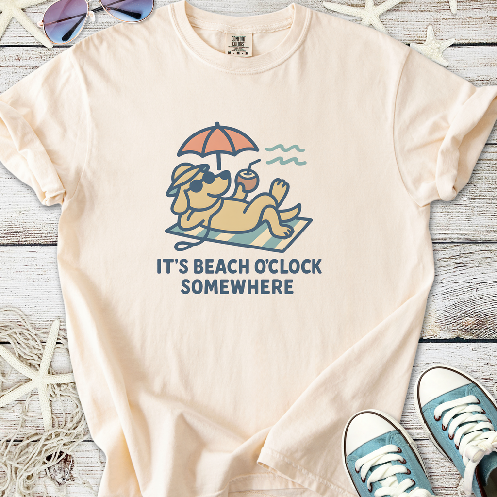 Cream graphic tee featuring a relaxed dog with sunglasses and the text 'It's Beach O'clock Somewhere'.