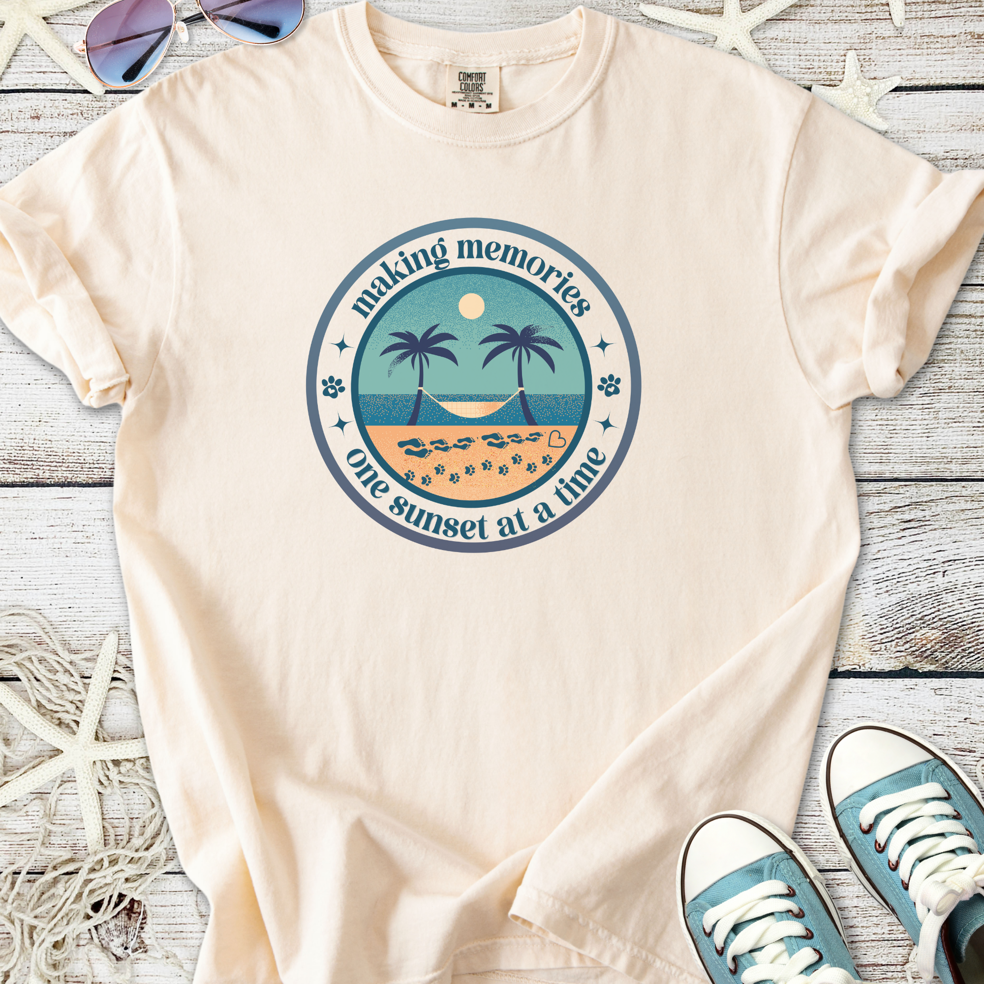 Soft beige t-shirt featuring sunset and palm tree graphic, perfect for beach lovers.
