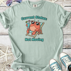 Light blue t-shirt featuring a relaxed crab graphic with sunglasses and a drink, saying 'Current Status: Not Moving'.