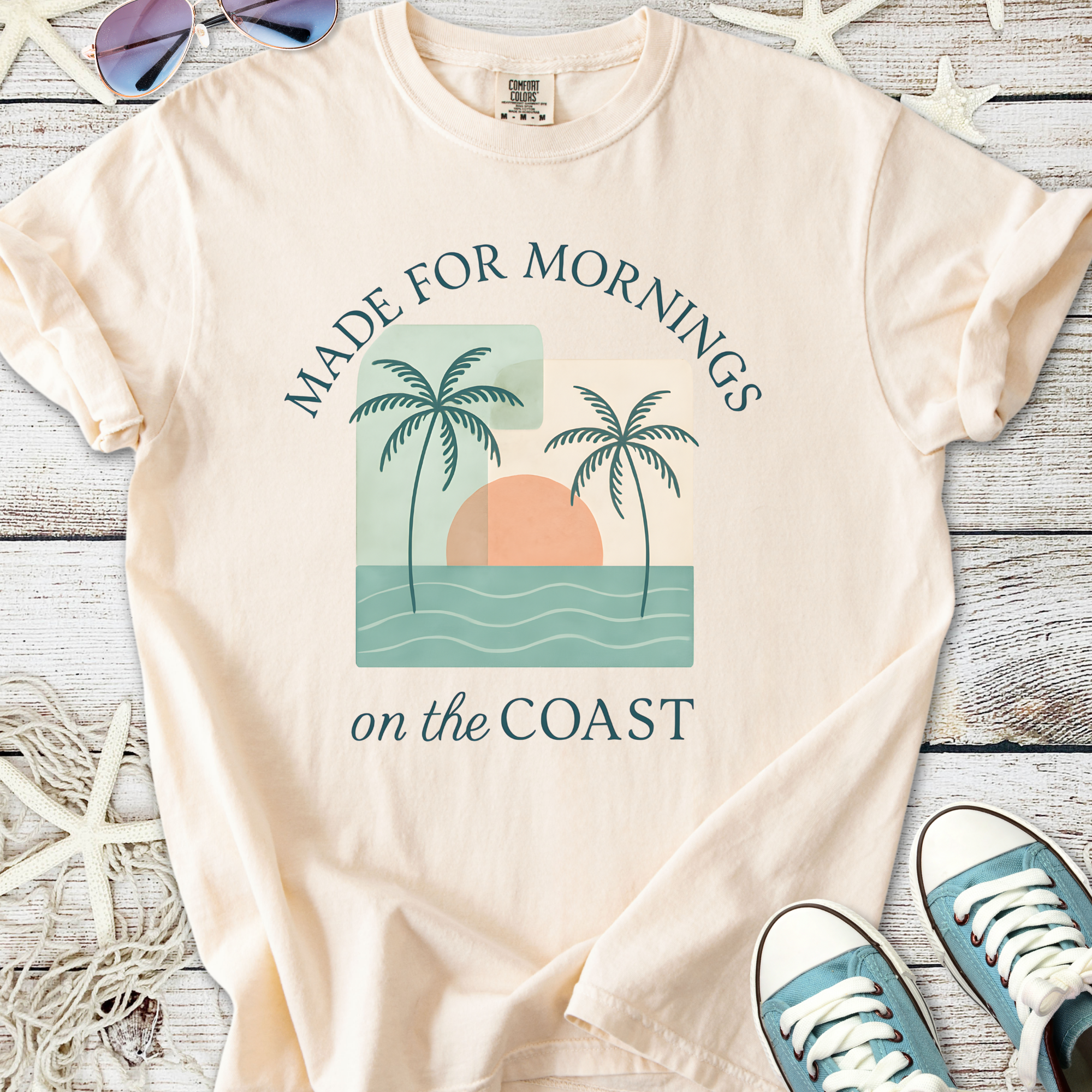 Peach beach-themed t-shirt with palm trees and sunset graphic, perfect for coastal mornings.