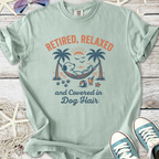 Light green t-shirt featuring a relaxed dog graphic, text 'Retired, Relaxed and Covered in Dog Hair'.