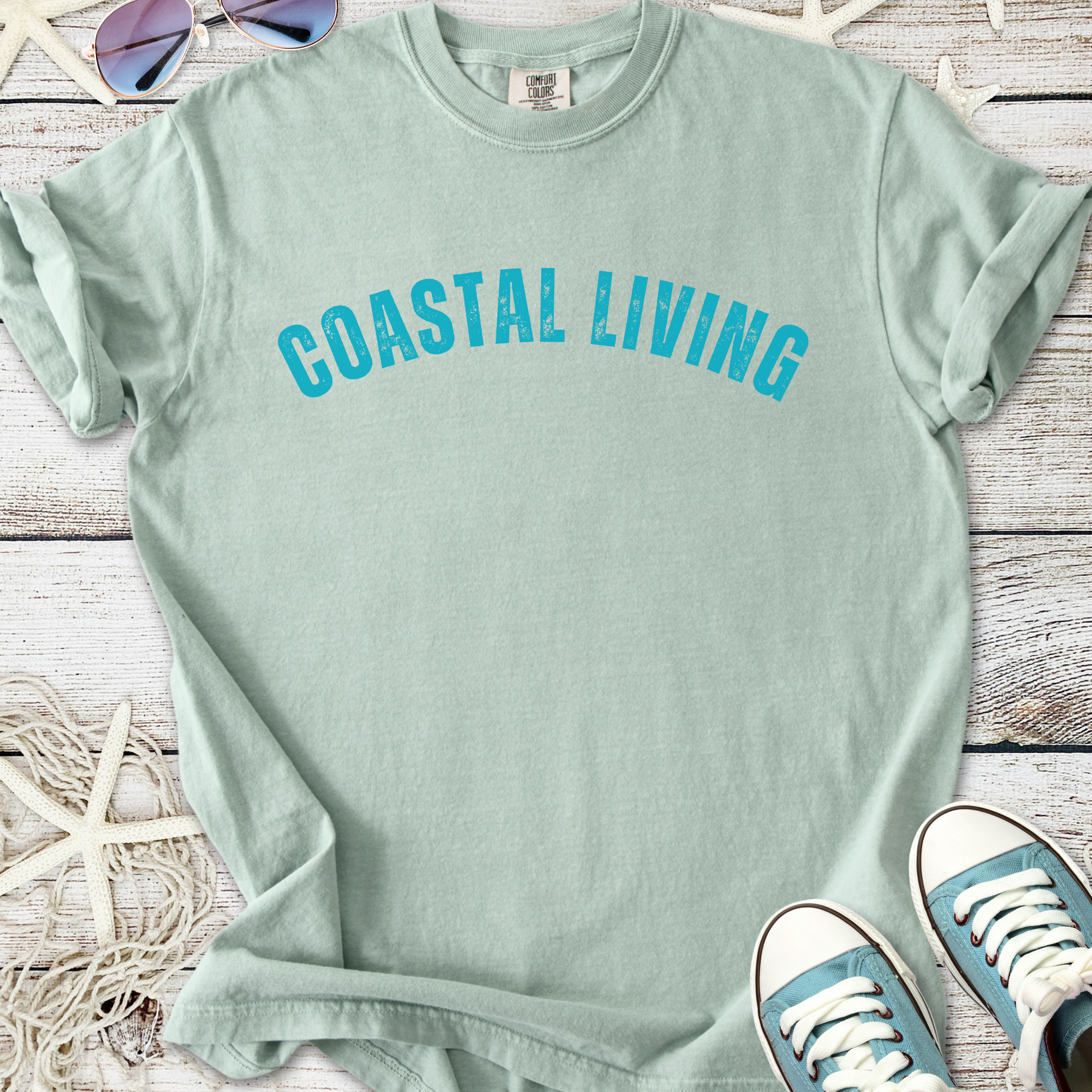 Mint green t-shirt with 'Coastal Living' graphic, relaxed fit, perfect for casual beach outings.