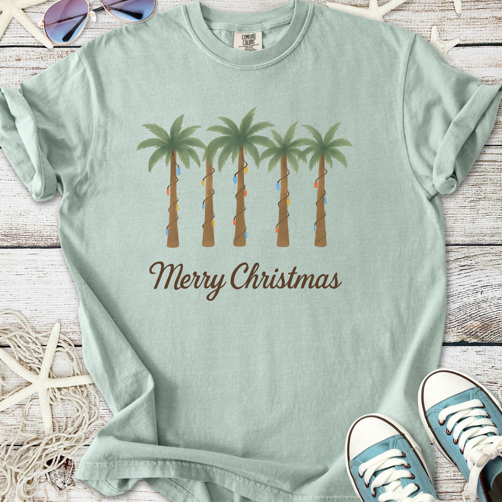 Light green Christmas t-shirt with palm tree design and 'Merry Christmas' text, perfect for festive occasions.