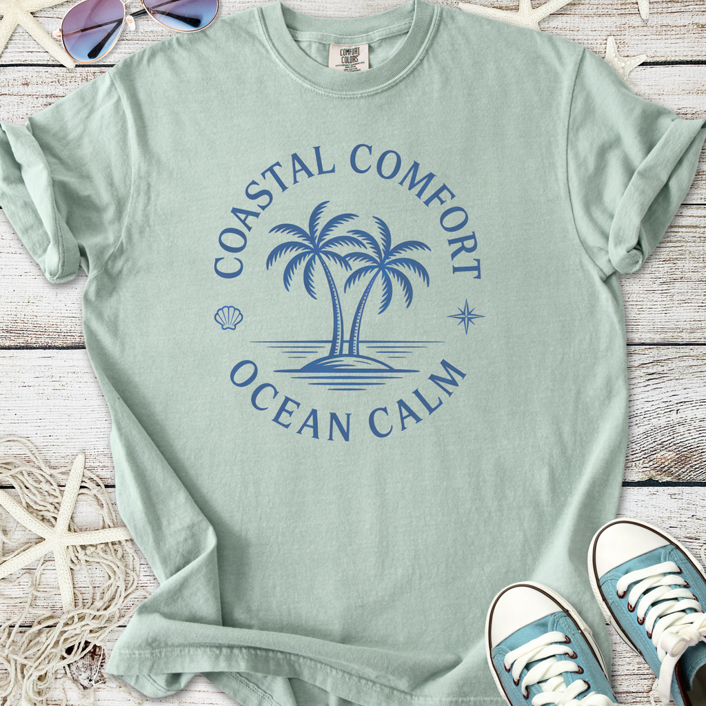 Mint green t-shirt featuring coastal comfort graphic with palm trees and ocean calm design.
