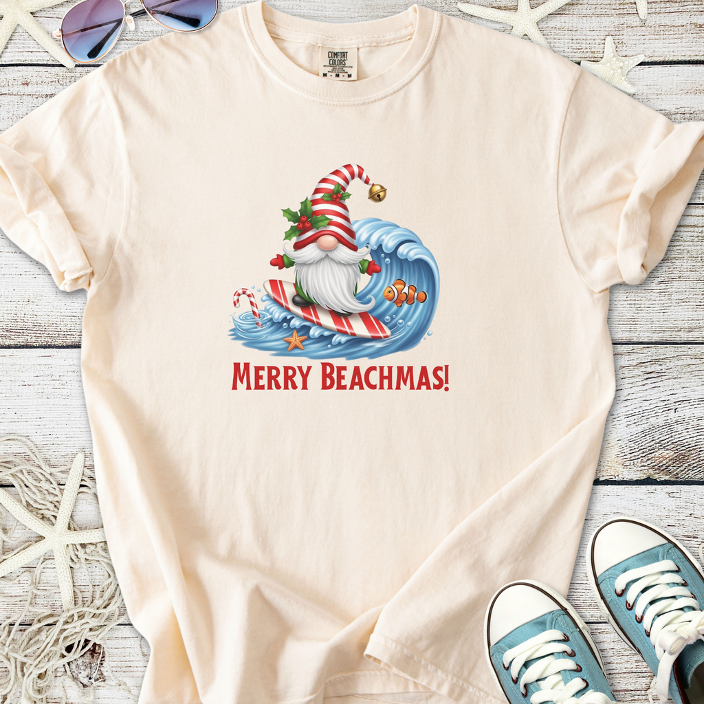 Cream t-shirt featuring a surfing Santa with 'Merry Beachmas!' print. Perfect for holiday beach celebrations.