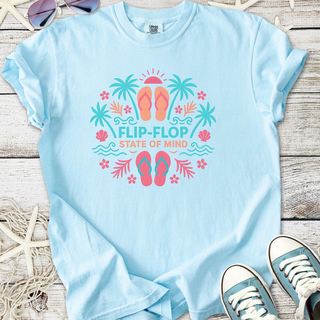 Light blue t-shirt featuring 'Flip-Flop State of Mind' graphic with tropical design and flip-flops.