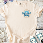 Cream retired t-shirt with beach graphic, perfect for relaxed beach days.