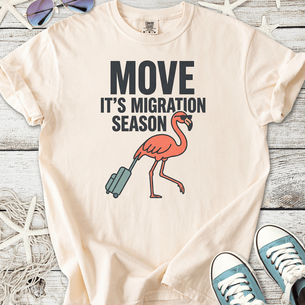 Light beige t-shirt with a fun flamingo graphic and text 'Move It's Migration Season'.