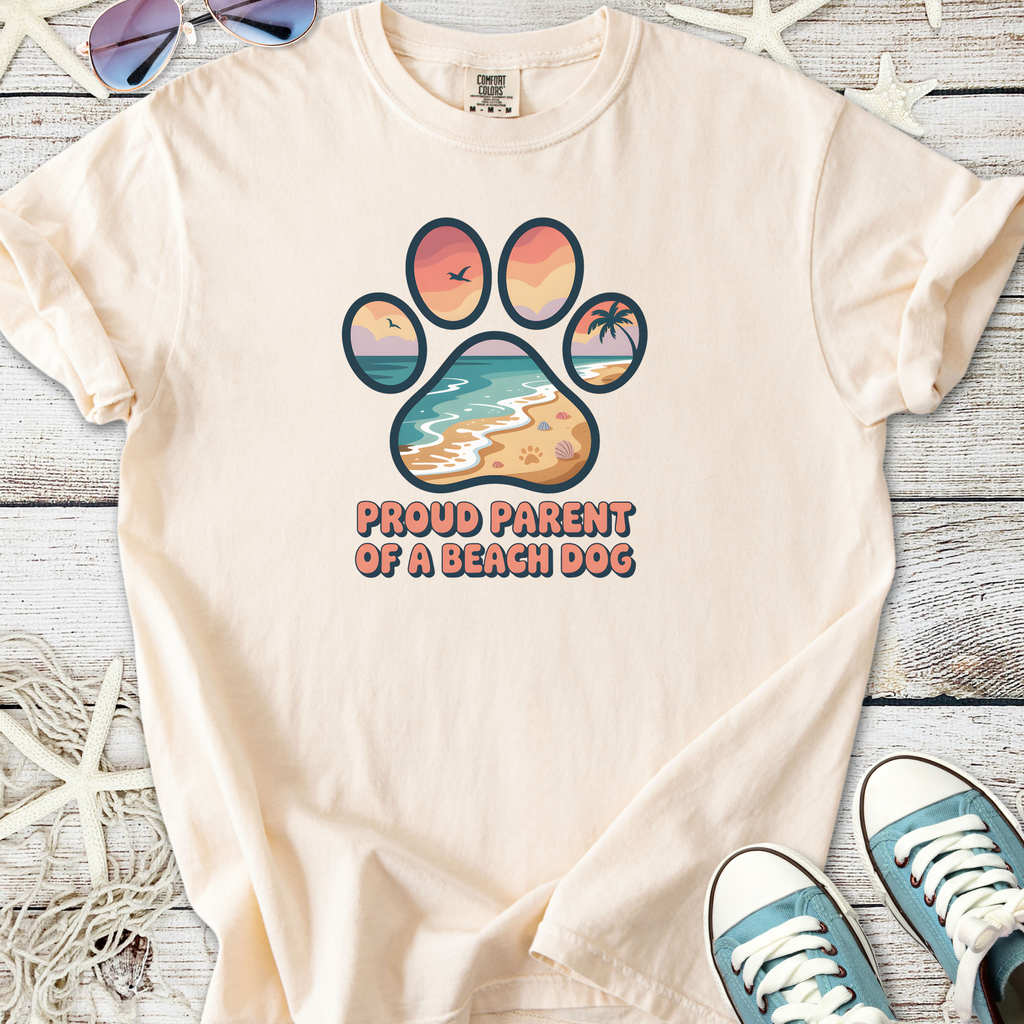 Cream t-shirt featuring 'Proud Parent of a Beach Dog' graphic with beach and paw design.