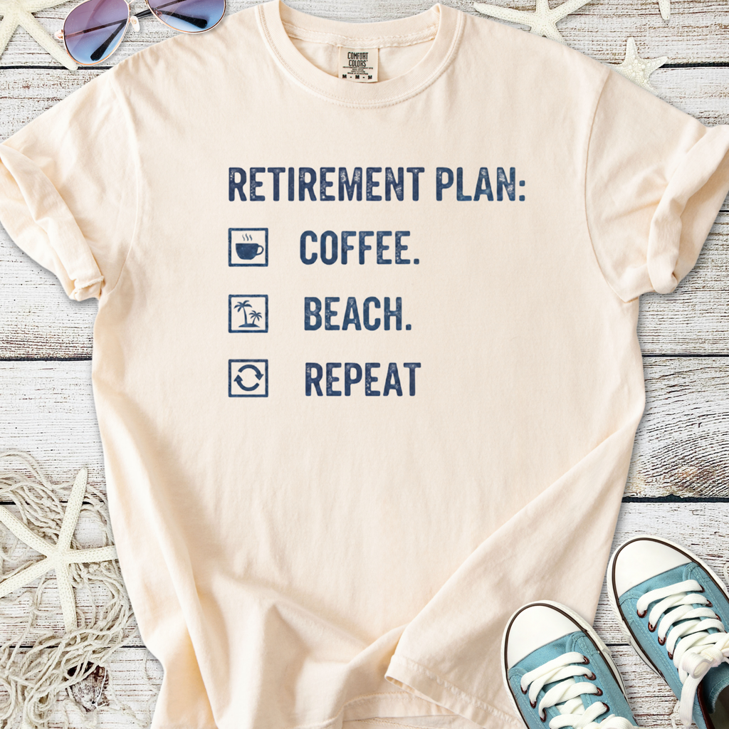 Light peach retirement plan t-shirt featuring coffee, beach, and repeat graphics in navy blue.