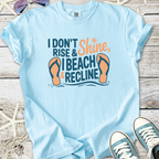 Light blue beach themed graphic t-shirt with flip flops and ‘I Don’t Rise & Shine, I Beach & Recline’ text