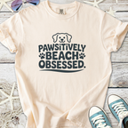 Light peach t-shirt with 'Pawsitively Beach Obsessed' graphic, perfect for dog lovers and beachgoers.