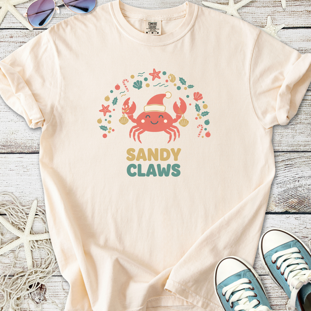 Cream t-shirt featuring a cute crab graphic with the text 'SANDY CLAWS', perfect for beach lovers.