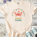 Cream t-shirt featuring a cute crab graphic with the text 'SANDY CLAWS', perfect for beach lovers.