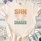 Beige cotton t-shirt with 'SUN CHASER' graphic, surfboard, and palm trees design, perfect for summer vibes.