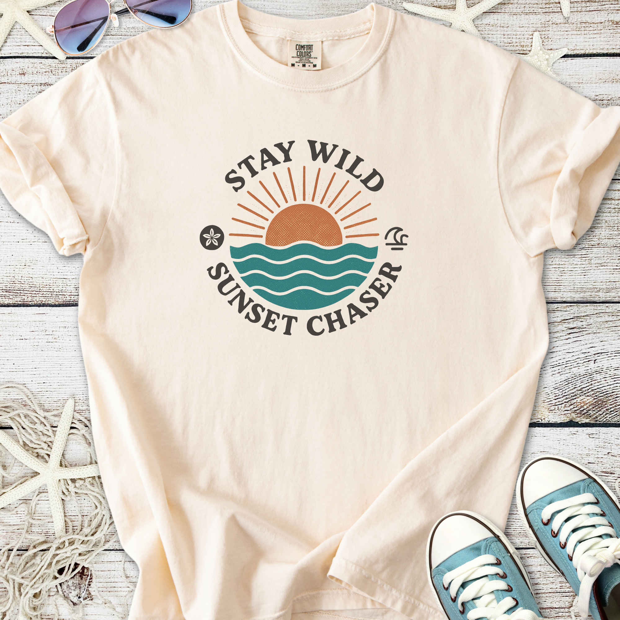 Cream cotton t-shirt with 'Stay Wild Sunset Chaser' graphic and ocean design, perfect for beach lovers.