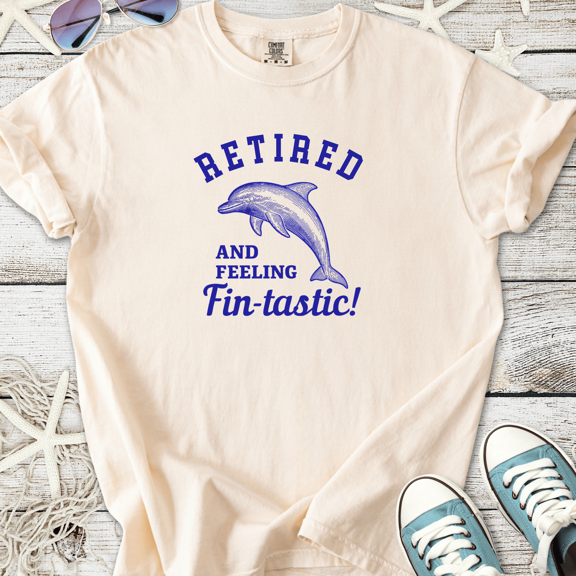 Cream cotton t-shirt with dolphin graphic and text 'Retired and Feeling Fin-tastic!'