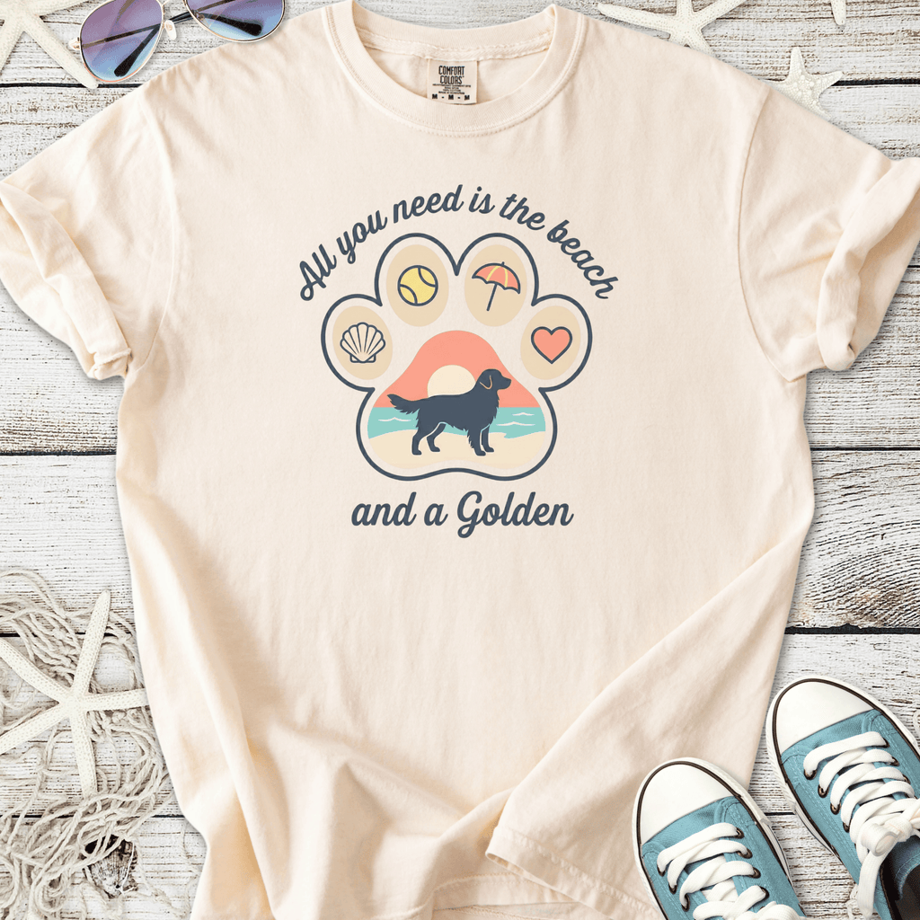 Beige tee shirt featuring a fun beach-themed graphic with a golden retriever silhouette and playful designs.