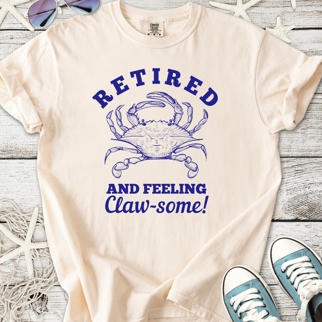 Cream t-shirt with blue crab graphic and humorous 'Retired and Feeling Claw-some!' text.