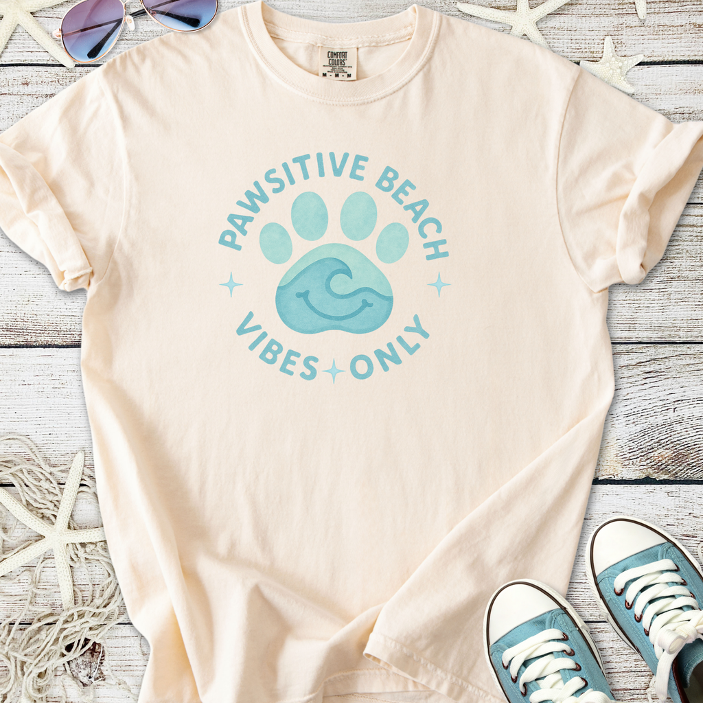 Light peach cotton t-shirt featuring 'Pawsitive Beach Vibes Only' graphic and paw print design.