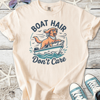 Cream graphic tee featuring a dog on a boat with ‘Boat Hair Don’t Care’ slogan, perfect for casual summer vibes.