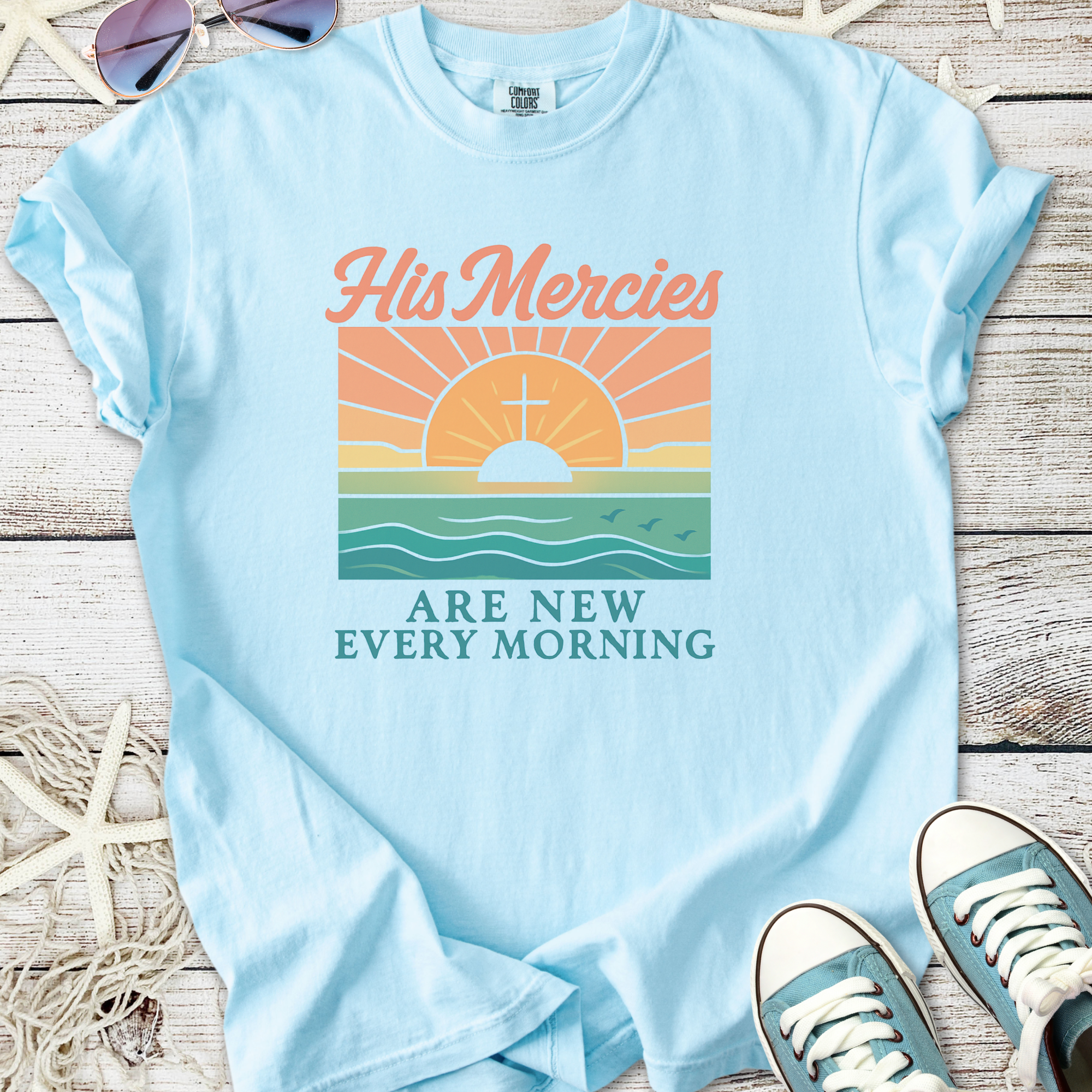 Light blue graphic t-shirt featuring sunrise design and text 'His Mercies Are New Every Morning'.