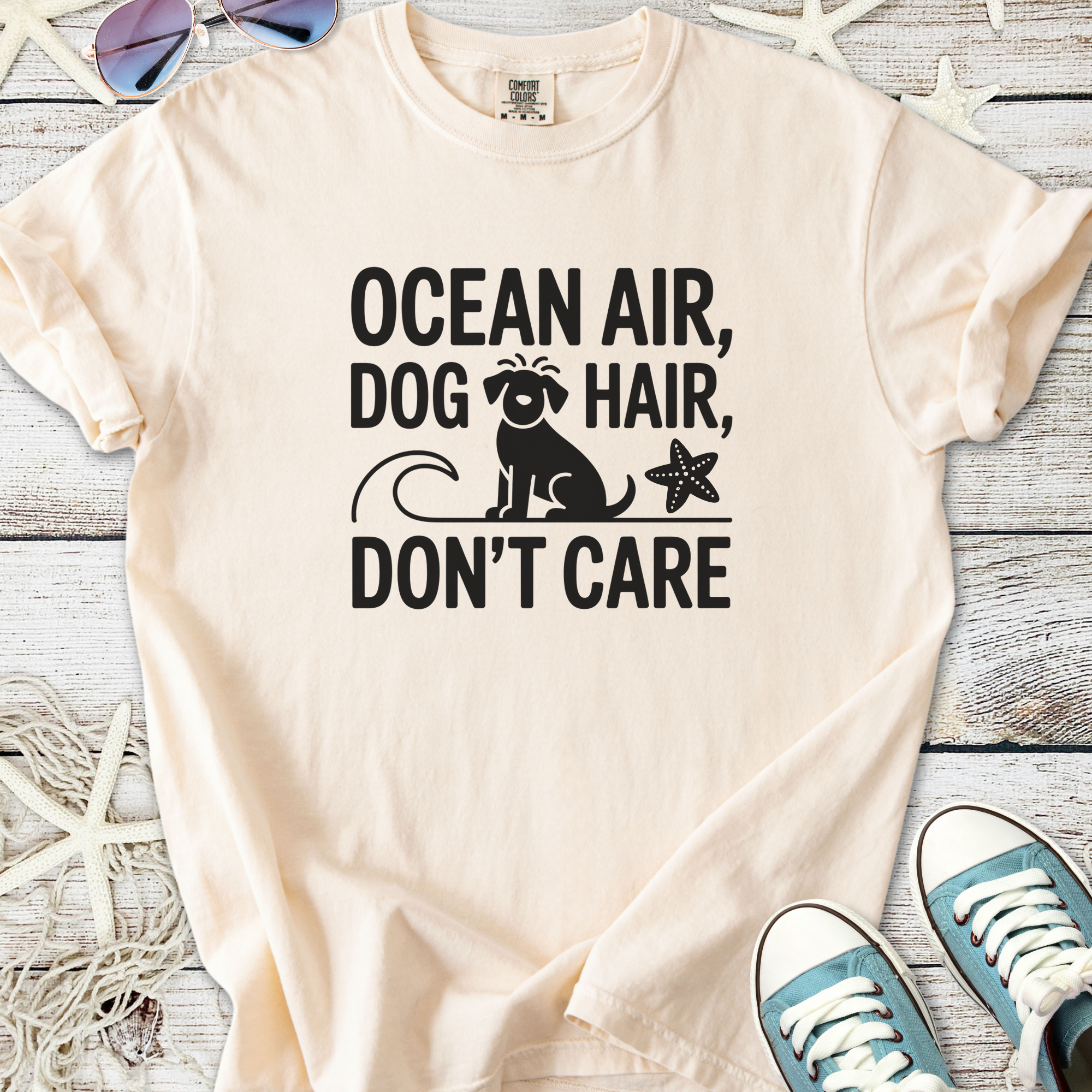 Light peach t-shirt with 'Ocean Air, Dog Hair, Don't Care' design featuring a dog and starfish.
