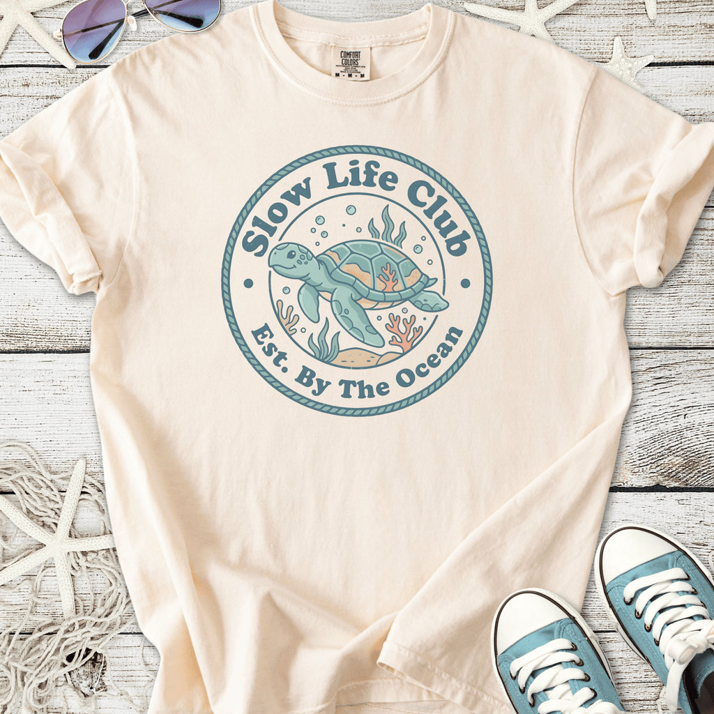 Beige cotton t-shirt featuring 'Slow Life Club' turtle graphic, ocean-themed design, perfect for beach lovers.