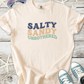 Cream t-shirt with 'Salty Sandy Unbothered' graphic, perfect for beach lovers and casual wear.