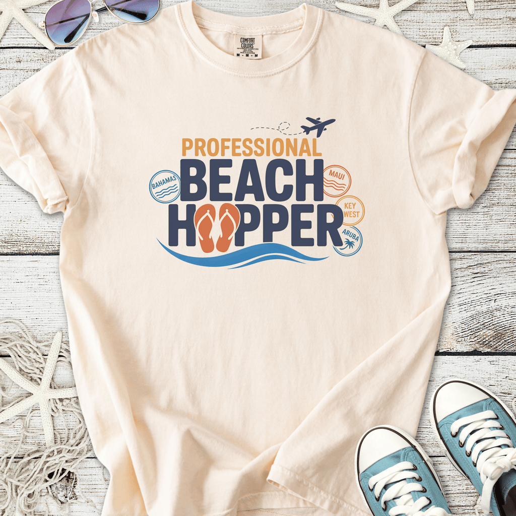 Light beige t-shirt with 'Professional Beach Hopper' graphic, featuring beach destinations and flip flop design.