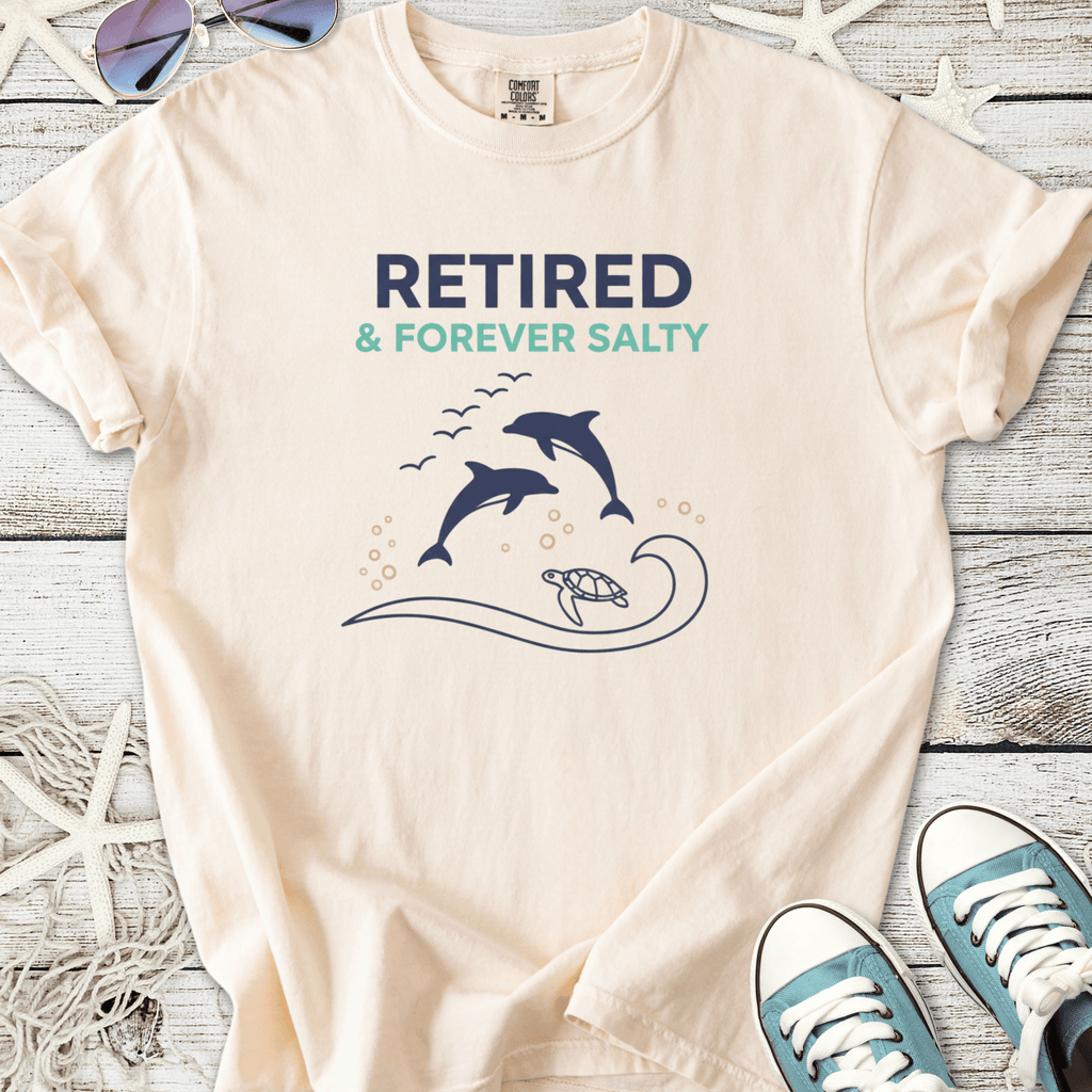 Cream t-shirt featuring dolphins and turtle design with 'Retired & Forever Salty' text.