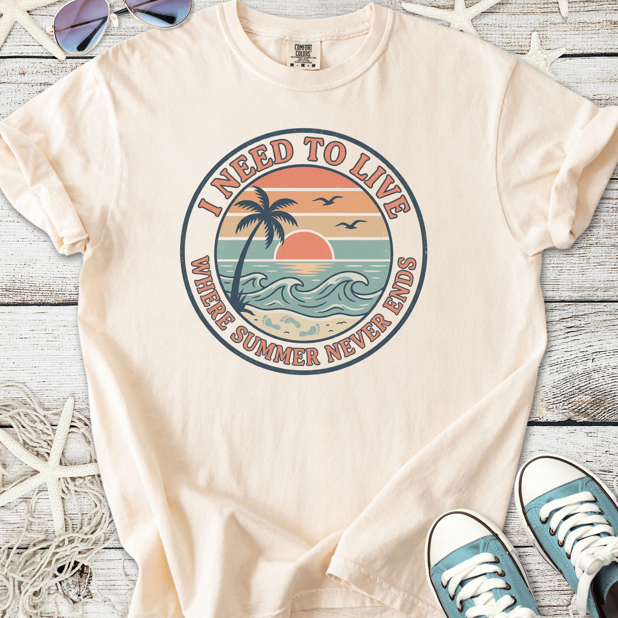 Men's beige t-shirt with 'I Need to Live' graphic, featuring a sunset and palm tree design.